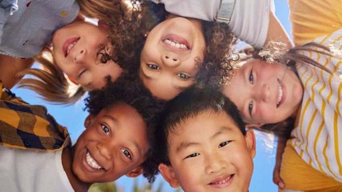 Friends, smile and below portrait of children outdoors for summer holiday, weekend and playing games together. Childhood, friendship and group of kids in circle for diversity, community and support.